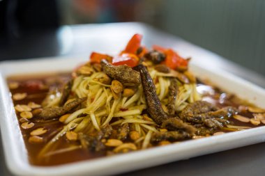 Mango spicy salad with crispy fish Thai food spicy Tasty Asian Food fusion style decorate nut and salted egg. Selective focus