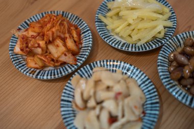 Lezzetli mezeler ve ahşap masada Kore mezeleri.