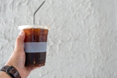 İş adamı, çimento arka planında siyah kahve fincanı tutuyor.