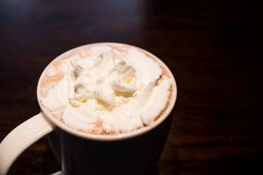 Bardakta sıcak kahvenin üstüne krema dökülmüş. Kapat.