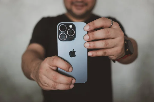 Bangkok, Tayland - 15 Aralık 2023: iPhone 15 profesyonel özellikleri ile fotoğraf çeken genç bir adam, 5x optik zoom ile üçlü lens kamera kurulumu.