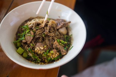 Tayland bifteği berrak çorba beyaz pirinç erişteli vermicelli ve haşlanmış biftek. Tayland 'da lezzetli sokak yemekleri. Seçici odak.