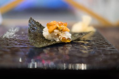 Taze deniz kestanesi yumurtası pilav ve somon yumurtası ile kaplanmış yosun. Kapat.