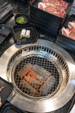 Japon usulü ızgara için çiğ et dilimi, tepside yakiniku ve pişirmeye hazır boş soba.