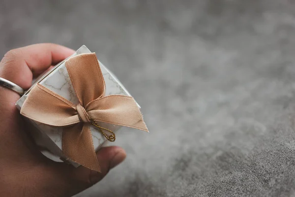 Man hand holding a box of wedding gift for guest, wedding souvenirs