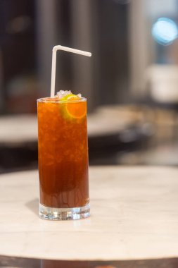 Beyaz pipetli bir bardak buzlu limon çayı. Kapat.