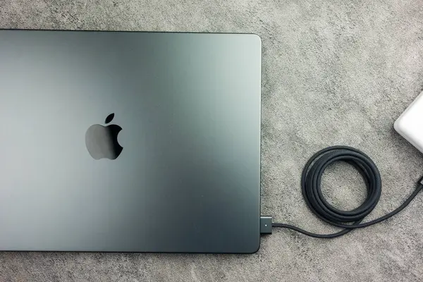 Bangkok, Tayland - 24 Aralık 2023 MacBook Pro 14 inç, M3 Max 2023 Space Black M3 Max ve siyah şarj kablosu bir konnektöre takılı.