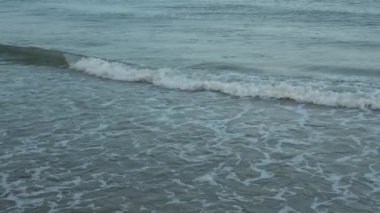 Deniz dalgasını kapatın. Köpüklü suyu sakinleştirmek için yaz tatili konseptini kullan. Plajda tatil. Yaz günü sahilin manzarası..