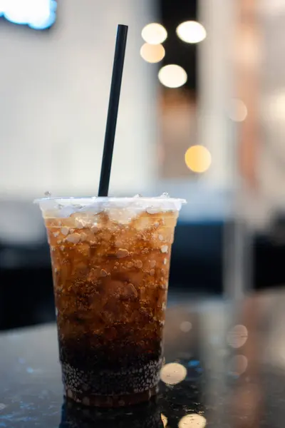 Cups of soft drinks in crushed ice with straw, sweet sugary soft drinks