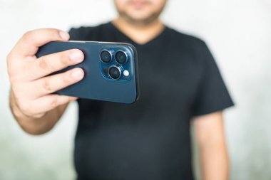 Bangkok, Tayland - 28 Aralık 2023: Yeni iPhone 15 Pro Titanyum mavisi el ele tutuşan adam üç kameralı bir fotoğraf çek