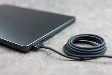 Bangkok, Tayland - 28 Aralık 2023: MacBook Pro M3 Max 'te siyah örgülü bir USB-C kablo şarj cihazı