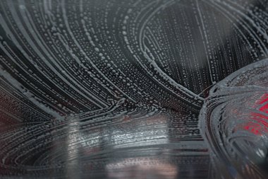 Driver view looking out through the windshield while going through an indoor automatic car wash.