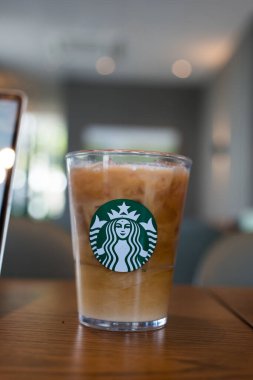 Bangkok, Tayland - 7 Ocak 2024: Kahve tazeleyici içecek Starbucks logosu ile birlikte kahve dükkanının arka planında servis ediliyor. Starbucks en büyük kahve şirketi.