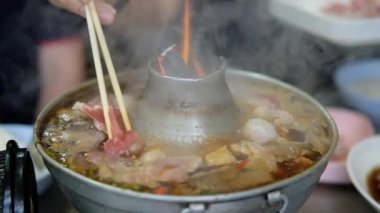 Tayland usulü paslanmaz çelik, alevli tencere. Börekli haşlanmış et ve sıcak tencerede köfte çorbası