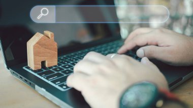 Erkekler gayrimenkulle ilgilendikleri şeyi bulmak için bilgisayar laptopu kullanırlar. İnternet ağındaki ev verileri aranıyor. Emlakçı iş konsepti