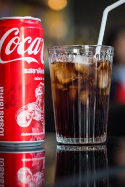 Bangkok, Tayland - 9 Ocak 2024: Bir kutu Coca-Cola ve buzlu temiz bir bardak. Coca-Cola dünyanın en sevilen karbonatlı içeceklerinden biridir..