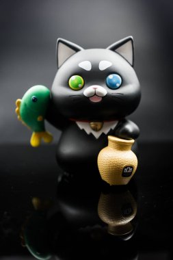 Bangkok, Tayland - 13 Ocak, 24: Şirin bir Khun ME Chok, bir BAAC tasarruf bankası, bambu çubuğunda balık yakalayan siyah bir kedi. Ulusal Çocuk Günü 'nde. Banka Tarım ve Tarım Kooperatifleri