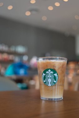 Bangkok, Tayland - 13 Ocak 2024: Kahve tazeleyici içecek Starbucks logosu ile birlikte kahve dükkanının arka planında servis ediliyor. Starbucks en büyük kahve şirketi.