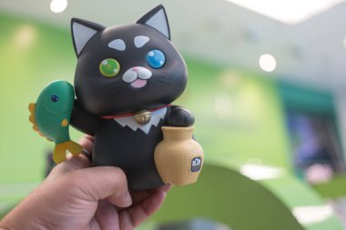 Bangkok, Tayland - 15 Ocak 2024: Ulusal Çocuk Günü vesilesiyle Adli Tıp Serisi 'nde bambu çubuğuyla balık yakalayan bir kara kedi olan Khun ME Chok adlı para kutusu.