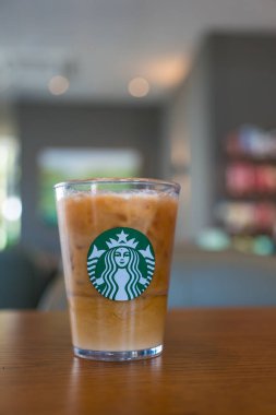 Bangkok, Tayland - 15 Ocak 2024: Kahve tazeleyici içecek Starbucks logosu ile birlikte kahve dükkanının arka planında servis ediliyor. Starbucks en büyük kahve şirketi.