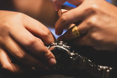 Bahar barı aletini kullanan bir saatçi. Yay çubuklarını kaldırmak için kullanılan yay çubuğu aracı saat kayışını değiştirmek için.