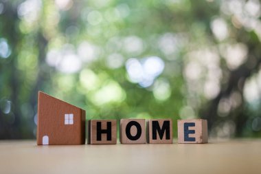 Bir evin kahverengi modeli ve ev sahibinin ahşap blokta doğa arka planına karşı metni metin alanınız için kopyalama alanı ile.