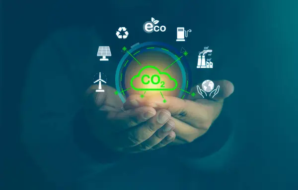 Hand holding digital screen while control and reduce carbon emission for global friendly business or ESG. Environmental concern, carbon credit and zero emission. Green fuel and earth protect