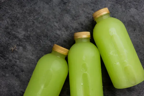 Bottles of cold pressed guava juice with golden lid three bottles. Top view