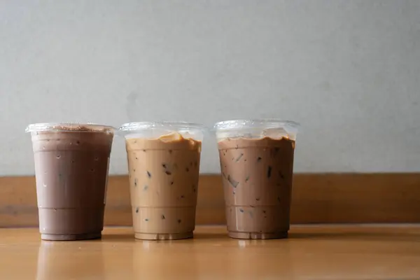 Close up view of iced mocha, Iced espresso and iced chocolate in plastic cup put on wooden desk