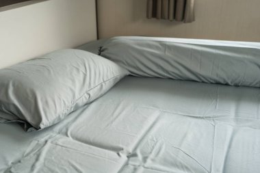 Yastık ve destek kapağı basit mavi bir yatakta.