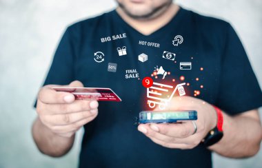 Erkekler internet üzerinden satın almak için akıllı telefon kullanıyor ve kredi kartı tutuyor, online ödemeler, online alışveriş, e-ticaret, internet bankacılığı ve para harcama kavramı. Evden alışveriş