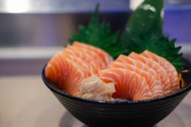 Somon balığı taze ve çiğ parçaları bir kasede servis edilir. Japon yemek tarzı.