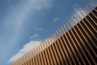 Modern ahşap çatının görüntüsü açık mavi gökyüzü ile çelişiyor. Güzel bir arkaplan resmi olarak kullanılabilir.