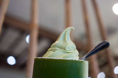 Yeşil çay, yeşil fincanda yumuşak servis ve elinde kaşık. Tatlı yemek için hazır..