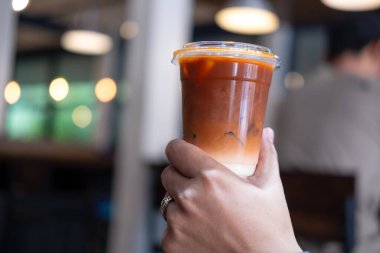 Bir bardak buzlu Thai sütlü çay. Tayland çayı uzun zamandır popüler olan geleneksel bir Tayland içkisidir..