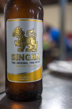 Bangkok, Tayland - 23 Haziran 2024: Restorandaki yemek masasına bir şişe Singha birası