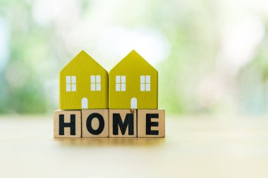 Yazılı eve ait iki adet yeşil model tahta blokta, doğal arka planda, metnin için fotokopi alanı olan ev. İnşaat, ekoloji, kredi kavramları için bir sembol