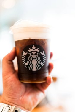 Bangkok, Tayland - 24 Haziran 2024: elinde Starbucks 'ın soğuk bira bardağını tutan adam. Starbucks soğuk bira içeceği