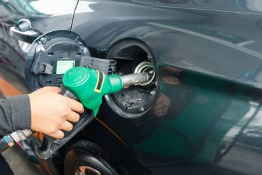 Benzin istasyonundan benzin dolduran tanınmayan bir adam benzin istasyonunda benzini dolduruyor. Petrol fiyatları konsepti