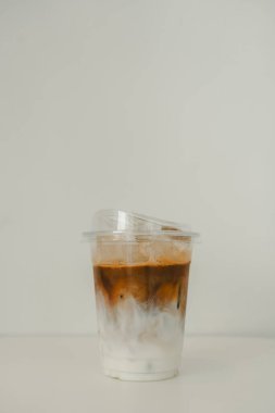 Soğuk buzlu latte kahve. Altında sütlü kahve, üstte ise plastik bardakta 16ons..