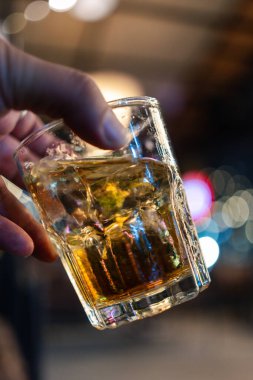 Bir elinde bardakta viski var.