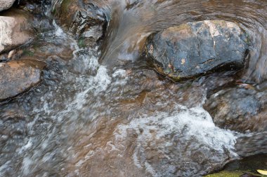 Yakın çekim ve şelale akıntısının üst görüntüsü. Taşlar doğa üzerinde. Doğal ortamda berrak hareket suyu.