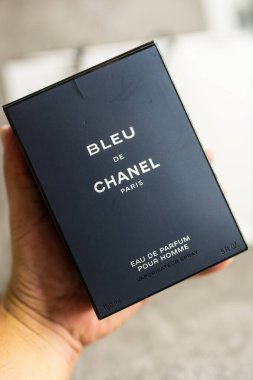 Bangkok, Tayland - 10 Temmuz 2024: Bir adam erkekler için bir şişe Blue de Chanel gösteriyor. Parfüm Bleu de Chanel. Moda tasarımcısı Coco Chanel tarafından Paris 'te kurulan Fransız şirketi..