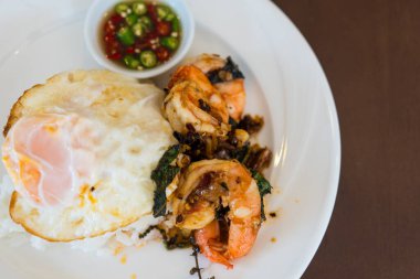 Kızarmış karides ve fesleğenli pilav üzerine kızarmış yumurta. Tayland baharatlı yemekleri..