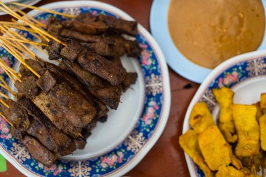 Tayland aperatifi, bambu şişlerinde karaciğer domuz eti fıstık sosu ya da tatlı ve ekşi sosla yenir. Asya yemekleri konsepti ve Tayland yemekleri