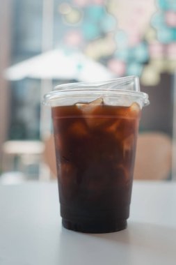Kahve dükkanında plastik bardaktaki buzlu kahveyi bitirmeye yakın..