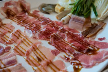 Biftek ve deniz ürünlerinin karışımı, sıcak tencerede hazır.