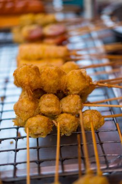 Sokakta satılan şiş şişlerle haşlanmış domuz eti köfteleri. Yerliler ve turistler bu yiyeceği ucuz, ucuz ve hızlı bir şekilde yiyorlar. Lezzetli atıştırmalıklar.