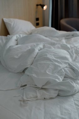 Beyaz buruşuk battaniye yastıklı yatak. Sabah otel odasında yapılmamış yatak.