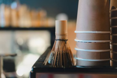 Bambu kibrit çırpıcı ve kahve dükkanındaki kahve makinesinin tepetaklak duran kahverengi kravat fincanları..